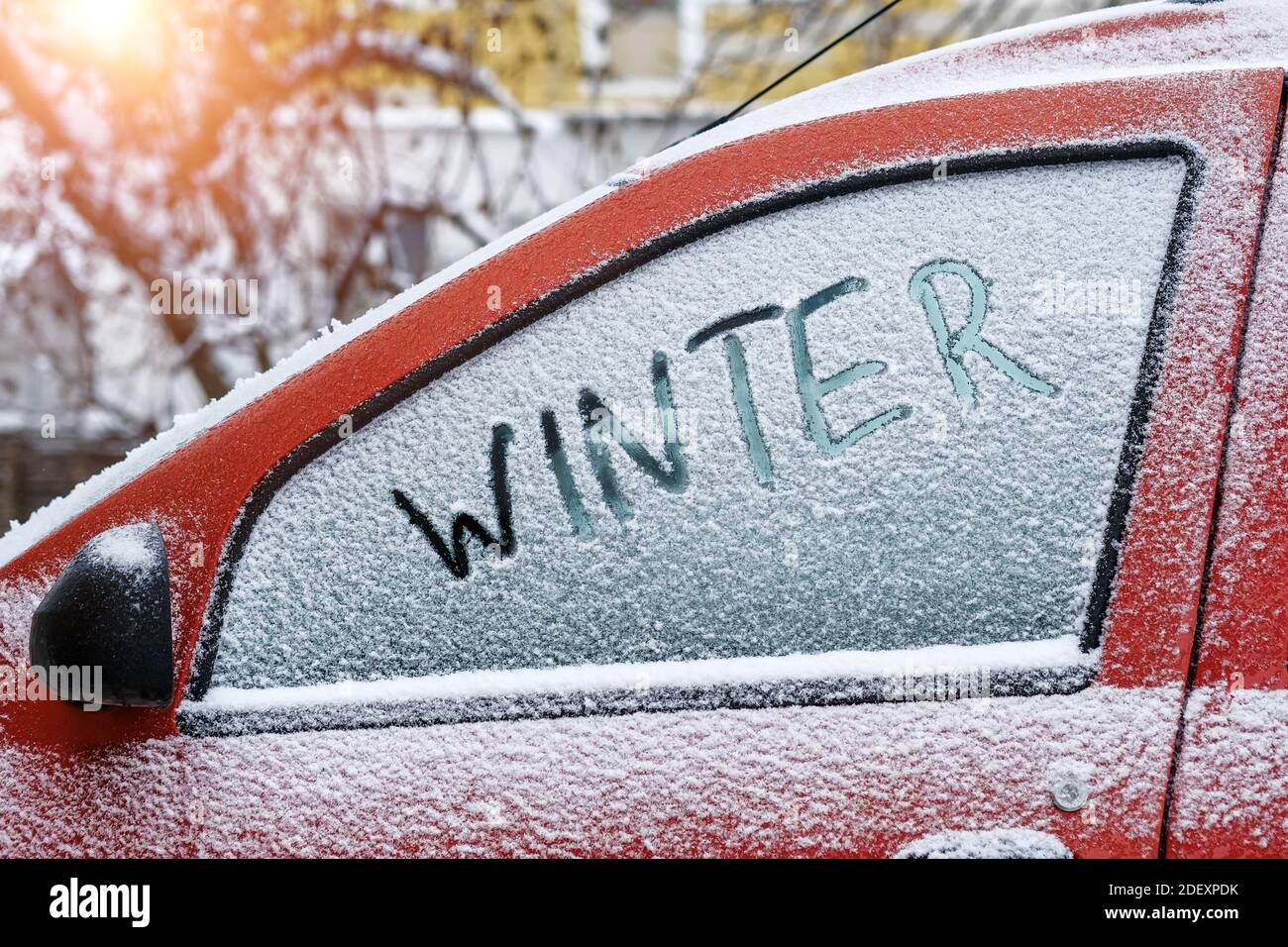 Word Winter escrito con el dedo en una ventana de nieve de un coche Foto de stock