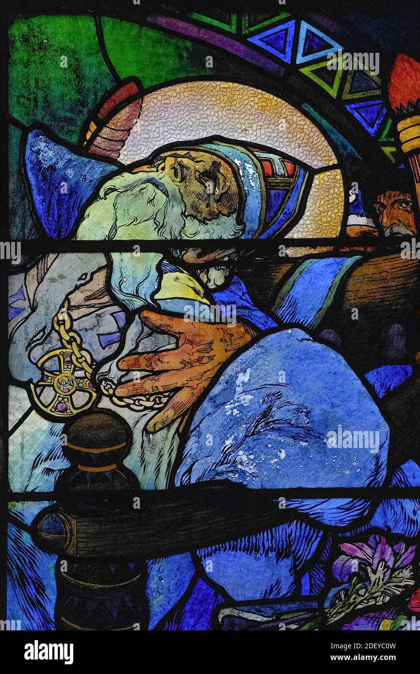 El luto coloca el reconfortante brazo alrededor de los hombros del agonizante teólogo bizantino y misionero San Metodio (815-885 DC), en vívido 1930 vidrieras del influyente artista Art Nouveau Alphonse Mucha en la capilla del nuevo arzobispo de la Catedral de San Vito en Praga, capital de la República Checa / República Checa. La ventana completa, una alegoría de Cristo que bendice a las naciones eslavas, presenta escenas de la vida de los ‘Apóstoles a los eslavos’ Metodio y su hermano Cirilo, así como el patrón checo san Wenceslao, Duque de Bohemia, y su abuela, San Ludmila. Foto de stock