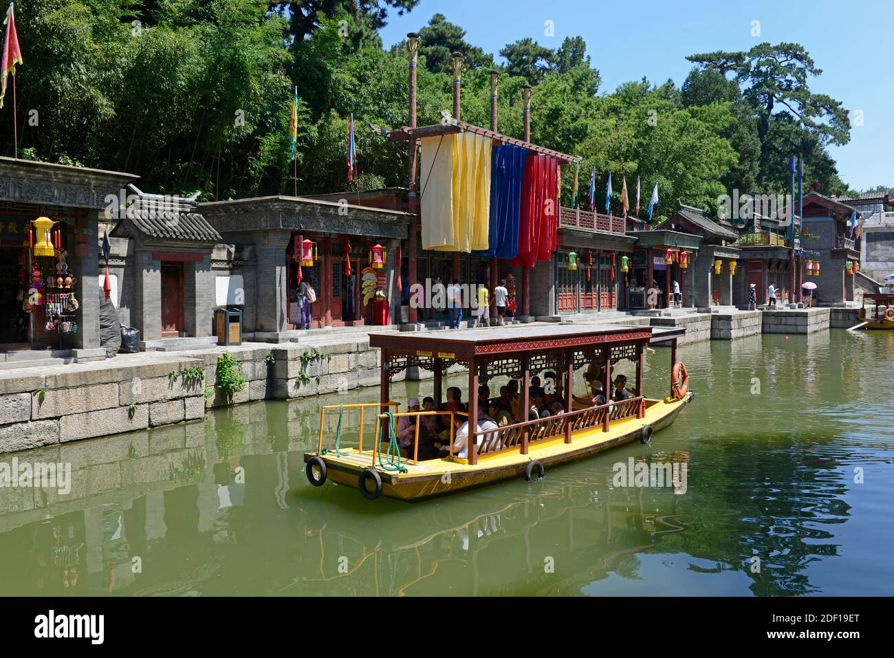 Los visitantes hacen un viaje en barco por las tradicionales tiendas turísticas que bordean suzhou creek por la puerta norte del Palacio de Verano en Beijing, China Foto de stock
