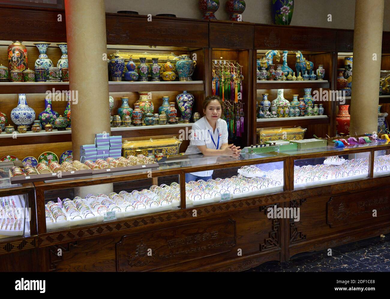 Un asistente de tienda se propone amablemente para una foto en una tienda en el Palacio de Verano en Beijing, China Foto de stock