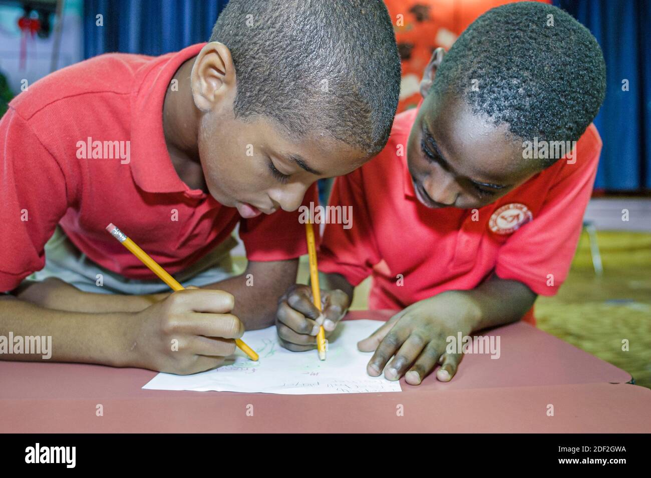 Miami Florida,Little Haiti Edison Park Elementary School,estudiantes negros africanos chicos varones escritura, Foto de stock