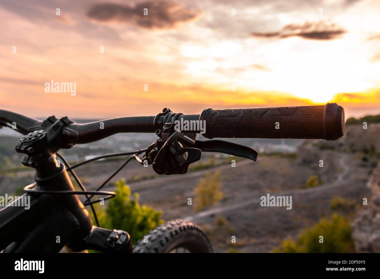 Detalle del agarre del manillar de la bicicleta. Bicicletas de montaña al atardecer. Foto de stock