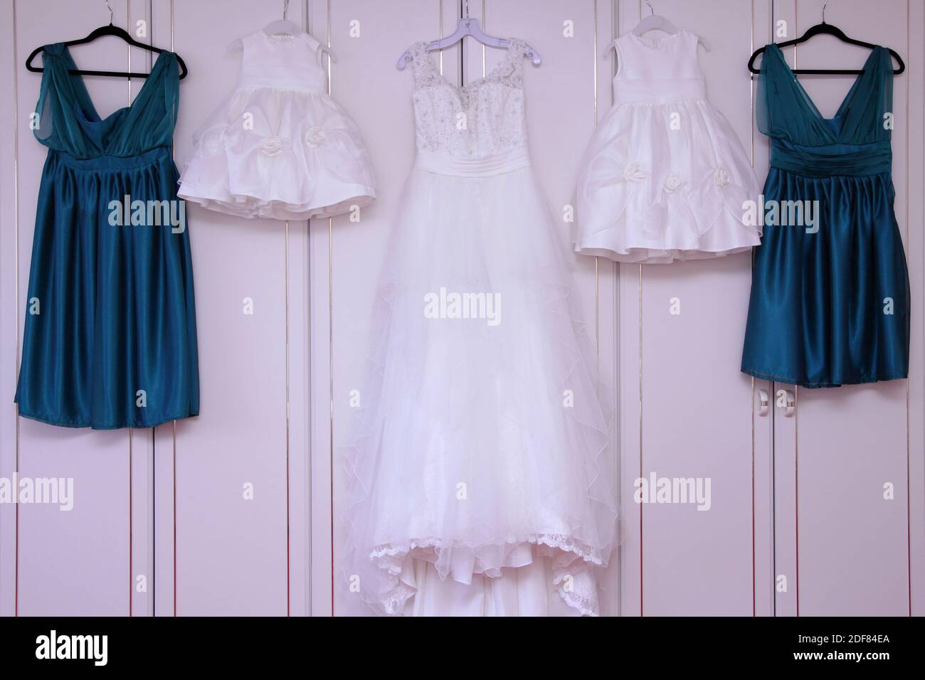 Vestido de boda, vestidos de niñas de flores o de niñas de flores y vestidos  de dama de honor en perchas de abrigo colgando Fotografía de stock - Alamy