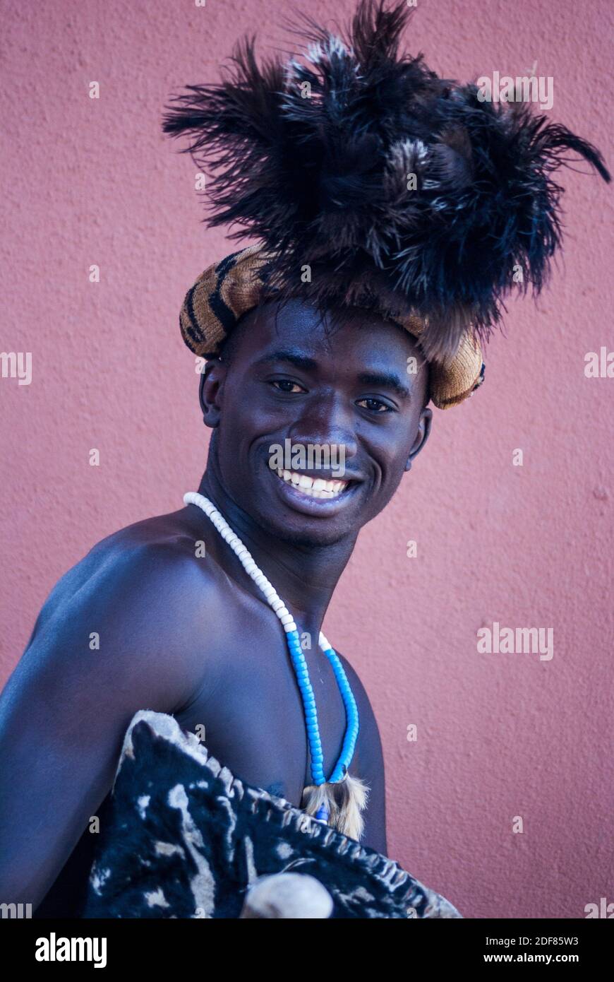 Retrato de un bailarín de compañía zambiana con vestido tradicional, alegremente posando para una foto. Troupe actuó para invitados en el Zambezi Sun (actualmente Foto de stock