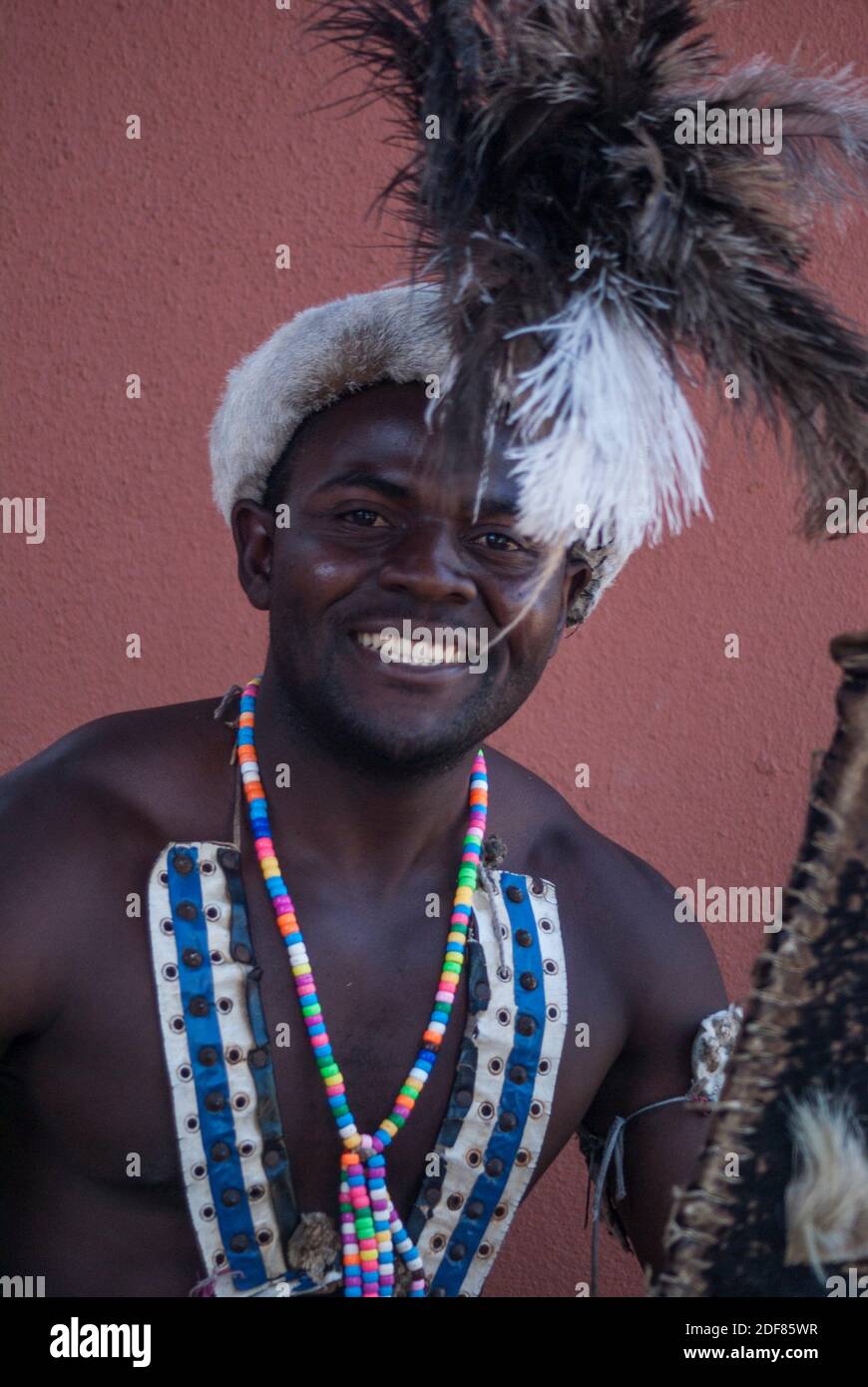 Retrato de un bailarín de compañía zambiana con vestido tradicional, alegremente posando para una foto. Troupe actuó para invitados en el Zambezi Sun (actualmente Foto de stock