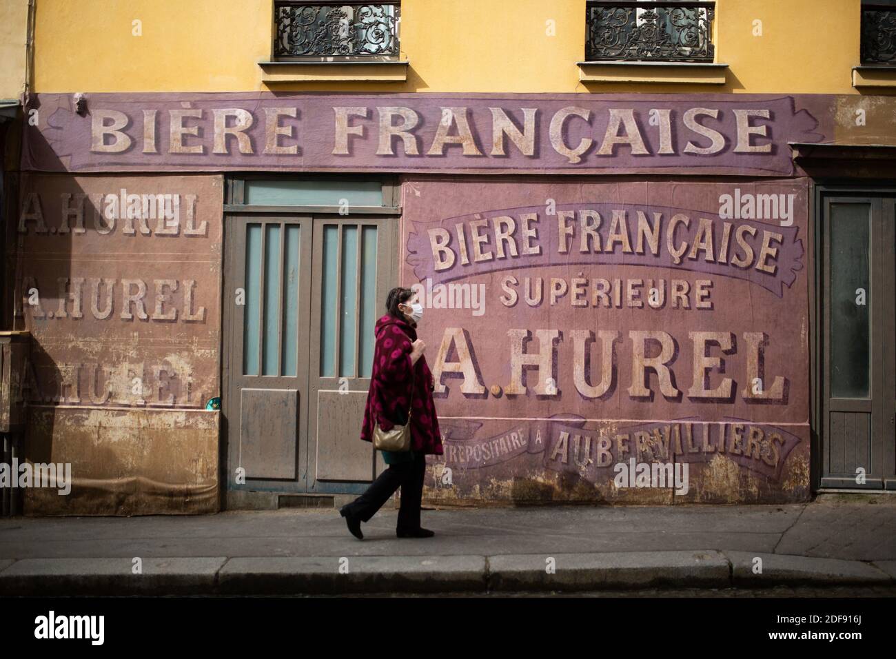 Una Persona Con Mascara De Cara Camina Delante De Un Cine Situado A La Izquierda Antes Del Final De La Filmacion De La Pelicula Adieu Monsieur Haffmann Dirigida Por Fred Cavaye En