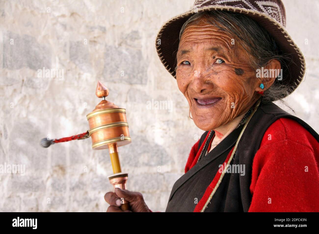 Tibet, Lhasa, retrato vieja dama tibetana con rueda de oración Foto de stock