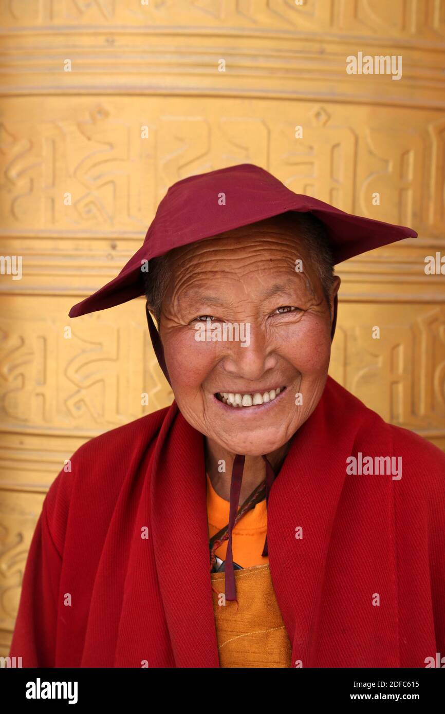 China, Sichuan, Tagong, Retrato de una mujer tibetana sonriente con vestido tradicional Foto de stock