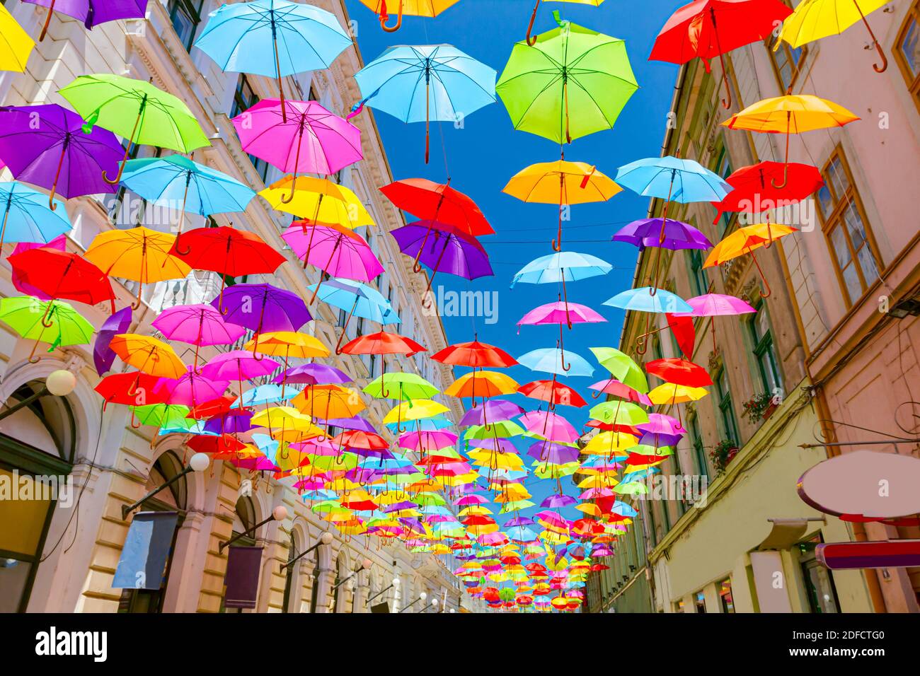 Los paraguas de colores están colgando coloreando el cielo sobre la calle  de la ciudad, barrer por encima Fotografía de stock - Alamy