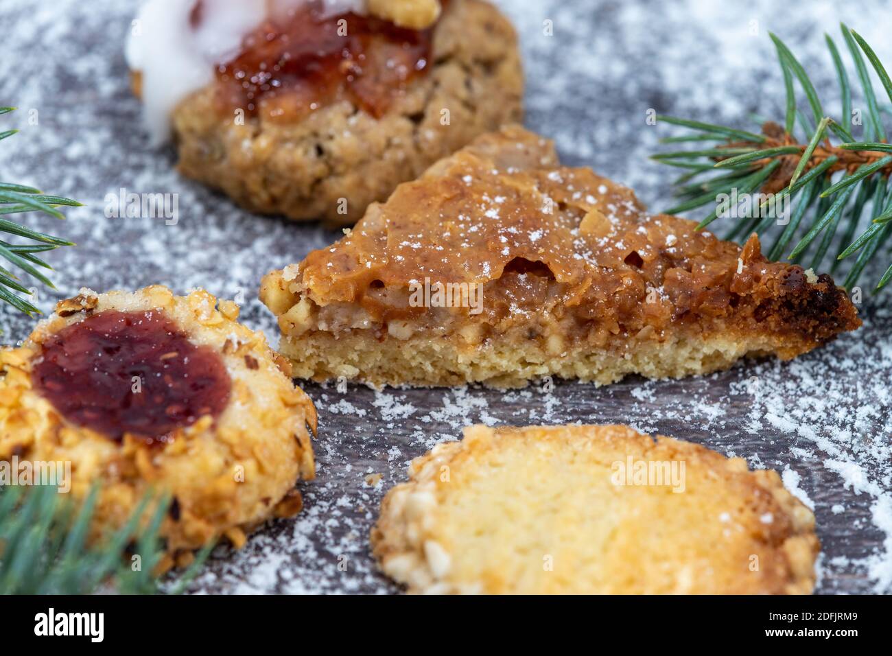 Primer plano de varias galletas de Navidad rodeado de azúcar en polvo y.. ramas de abeto Foto de stock
