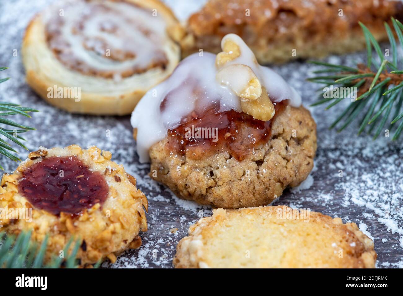 Primer plano de varias galletas de Navidad rodeado de azúcar en polvo y.. ramas de abeto Foto de stock