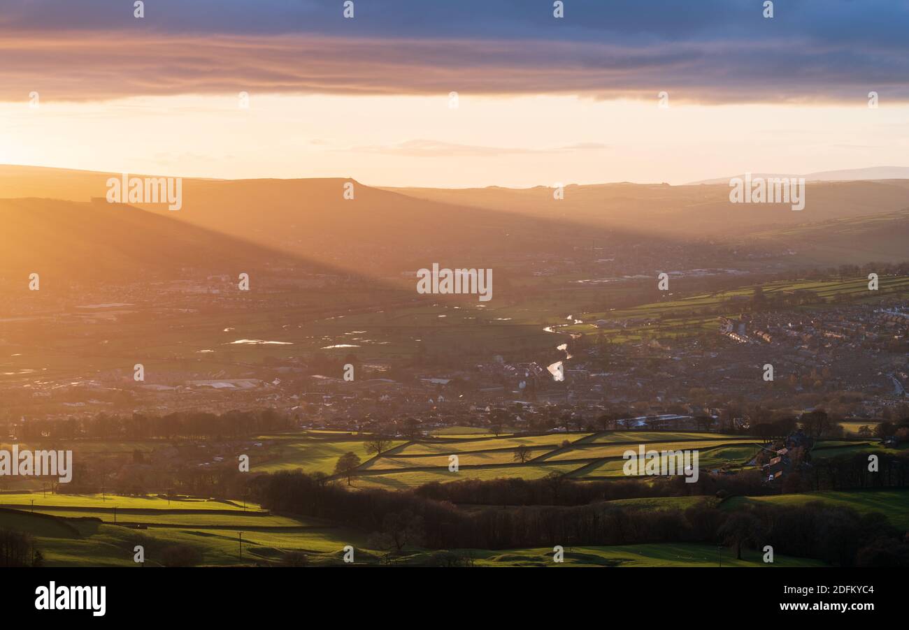 La puesta de sol arroja una luz espectacular sobre el pueblo de Silsden en el valle de Aire en una tarde de diciembre cambiante. Foto de stock