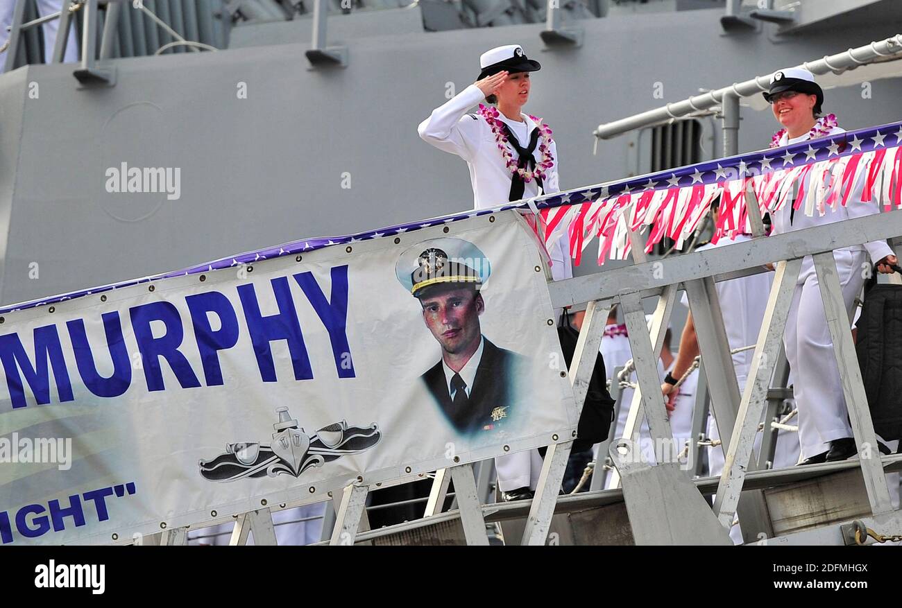 Foto del archivo de la entrega fechada el 16 de noviembre de 2012 de un marinero asignado al destructor de misiles guiados USS Michael Murphy (DDG 112) saluda al ensign mientras ella sale del barco en la base conjunta Pearl Harbor-Hickam. Ha habido un brote importante de coronavirus a bordo del USS Michael Murphy, que se ha extendido a casi una cuarta parte de los 300 tripulantes del buque, según dos funcionarios de la Marina de los Estados Unidos. El buque ha estado en el puerto de Hawai, por lo que ha habido un impacto operativo limitado debido al brote. Un funcionario dijo que la mayoría de los marineros que han contraído el virus no experimentaron síntomas y muchos lo son Foto de stock