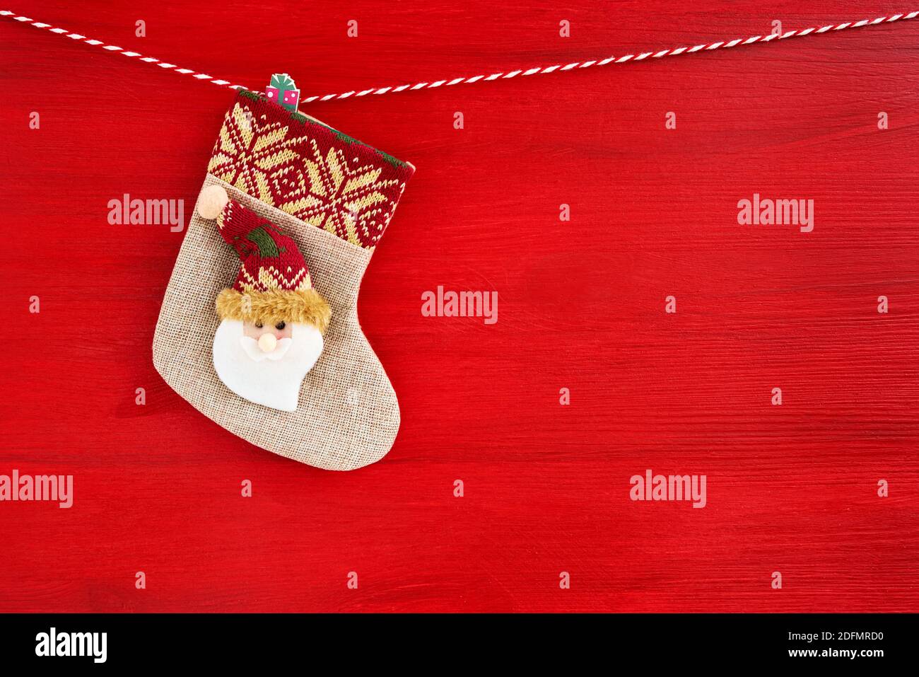 Rojo fondo de Navidad.calcetín de Navidad con Santa sobre fondo de madera rojo. Espacio de copia Foto de stock
