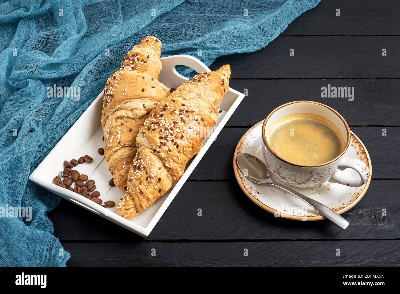 Croissants frescos y una taza de café sobre mesa negra. Espacio de copia, vista superior Foto de stock