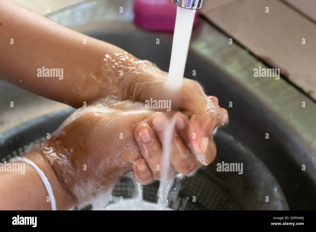 aplicar jabón y lavar con agua corriente limpia Foto de stock
