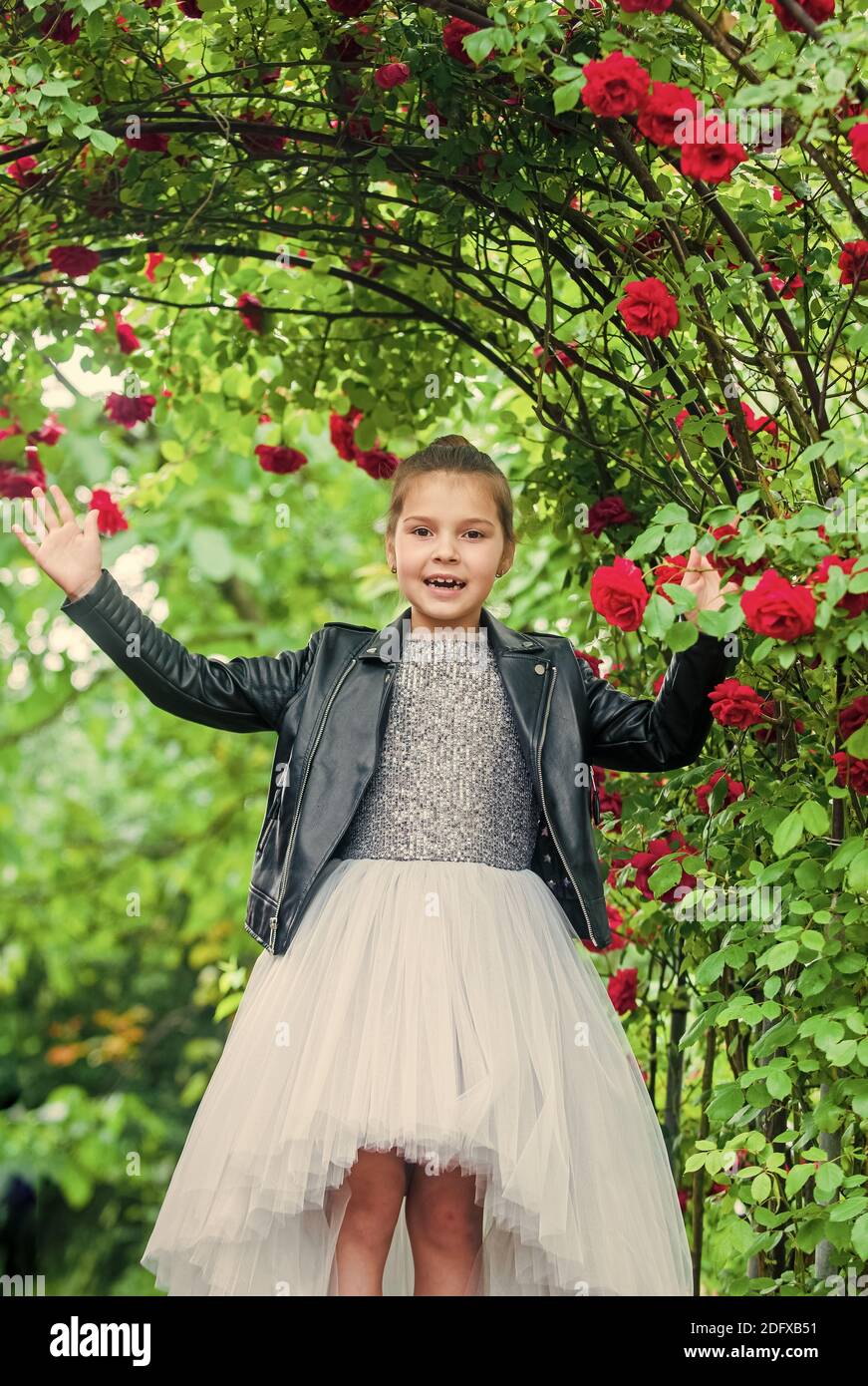 Moda niña vestido de lujo y chaqueta de cuero en el jardín de rosas, niñas concepto de poder Fotografía stock - Alamy