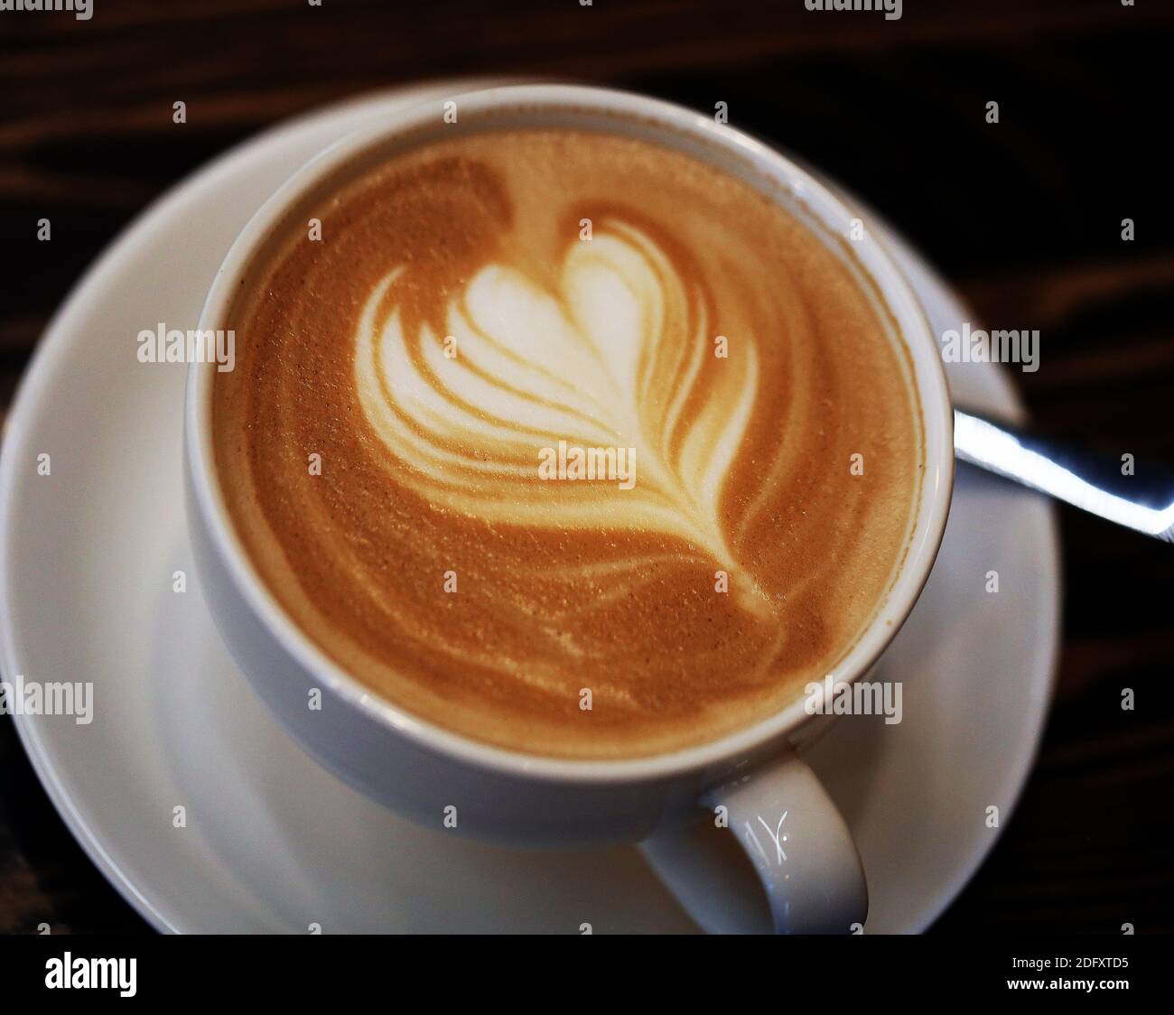 Foto macro de una taza de café y un corazón en un café. Ejemplo para anunciar café para un cartel Foto de stock