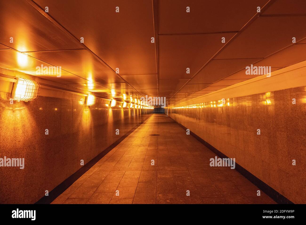 Pasaje subterráneo vacío iluminado con luz amarilla Foto de stock