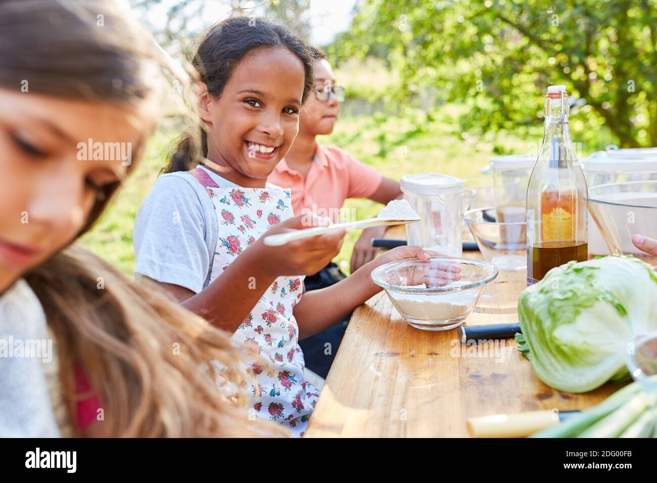 Chica feliz en clase de cocina para comer sano mientras se prepara ensalada Foto de stock