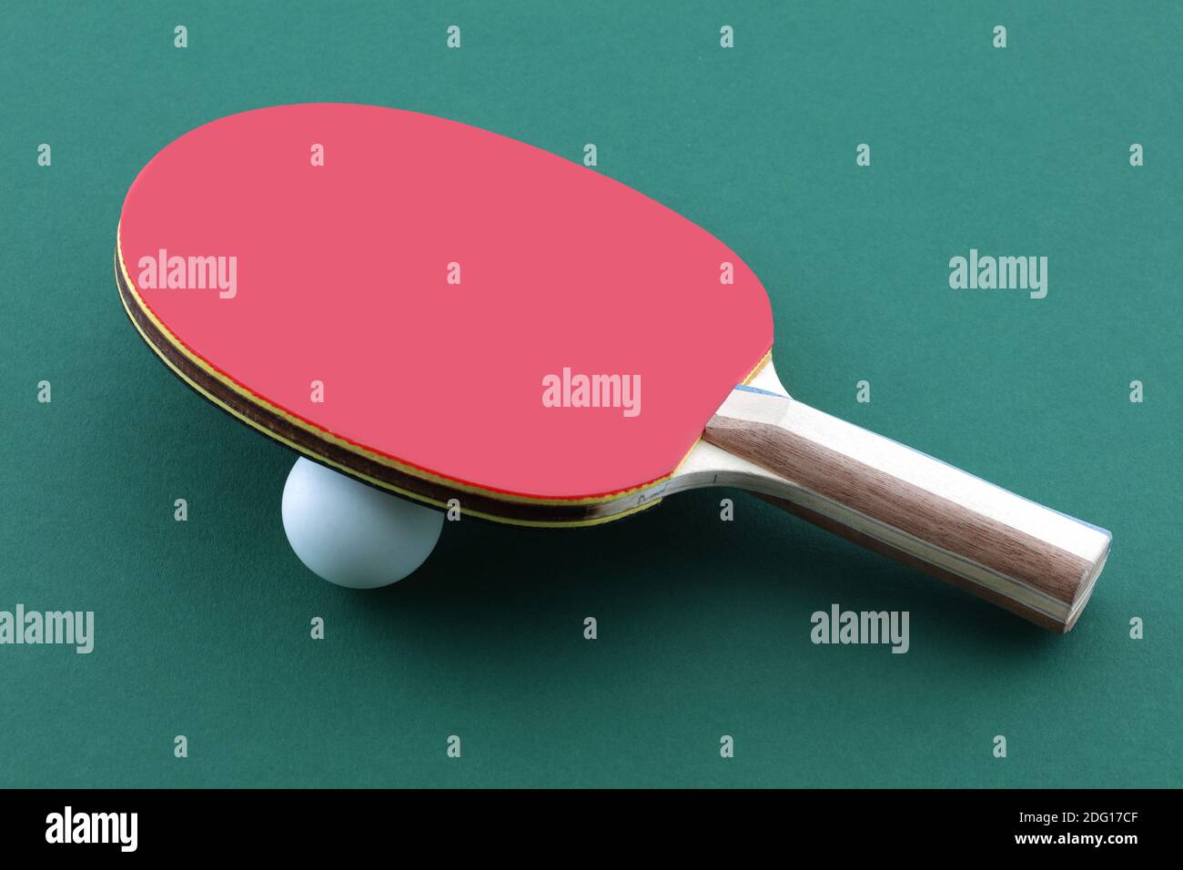 Palo de tenis de mesa y pelota blanca sobre ping de mesa verde pong paddle Foto de stock