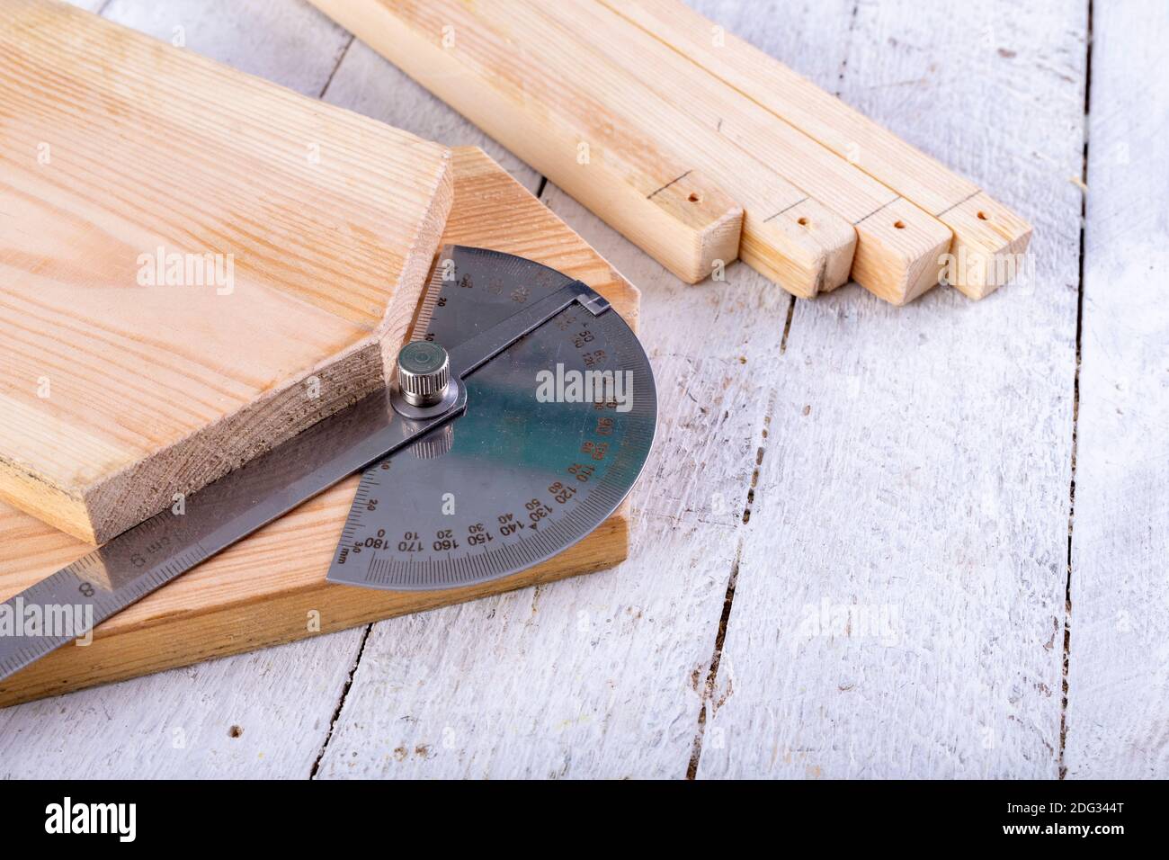 Un transportador de carpintero colocado en un pedazo de madera. Medición de  la kata en un taller de carpintería. Fondo claro Fotografía de stock - Alamy