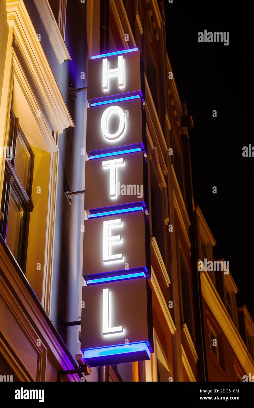 Señal del hotel en un edificio por la noche Foto de stock