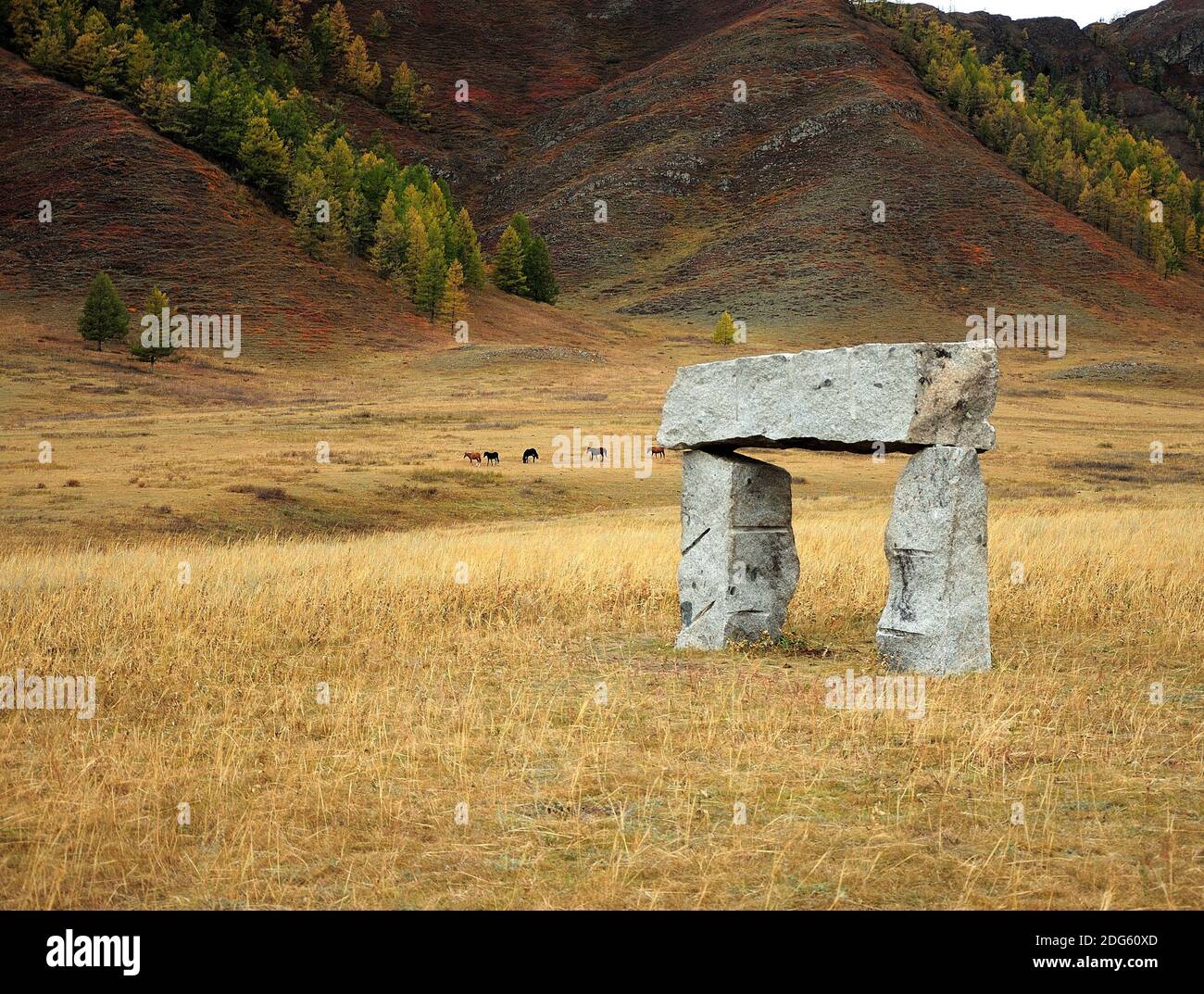 Un arco de piedra, una antigua estructura sagrada que se encuentra en la estepa otoñal al pie de una alta montaña. Karakol Valley, Altai, Siberia, Rusia. Foto de stock