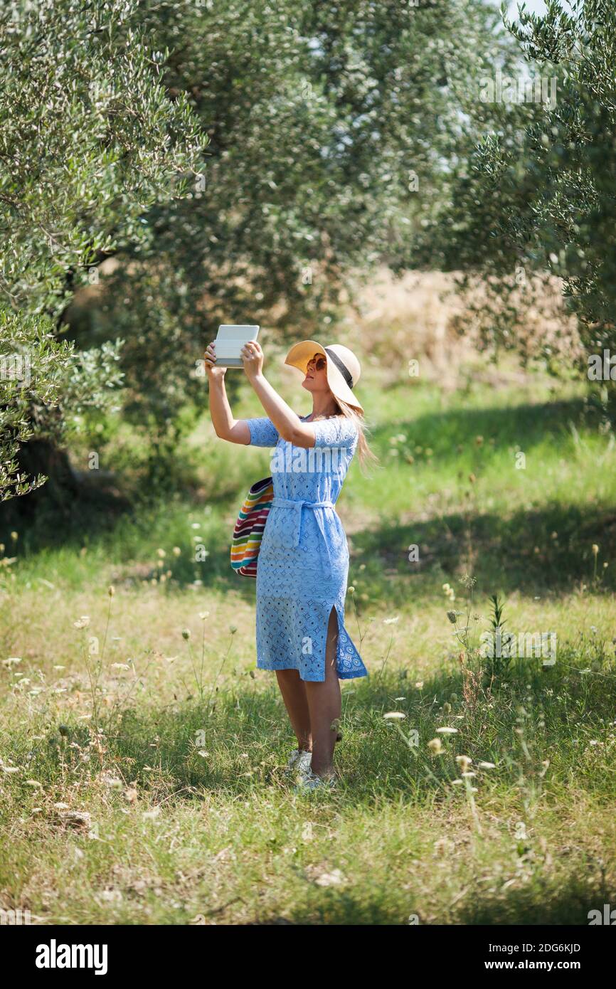 Mujer tomando fotos de la naturaleza con almohadilla de contacto Foto de stock