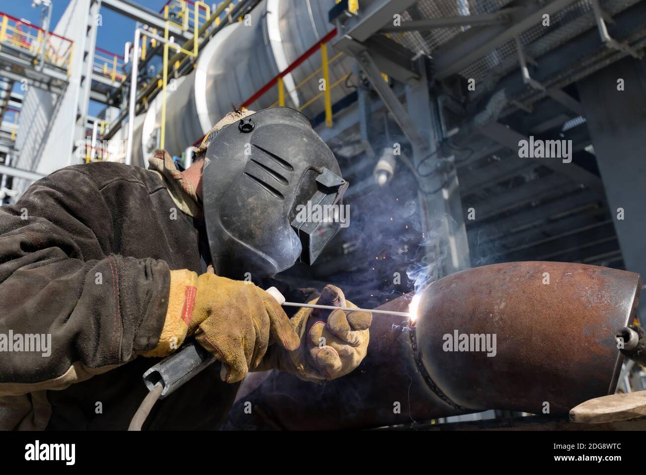 Trabajos de soldadura en el intercambiador de calor de metal usando soldadura manual por arco Foto de stock