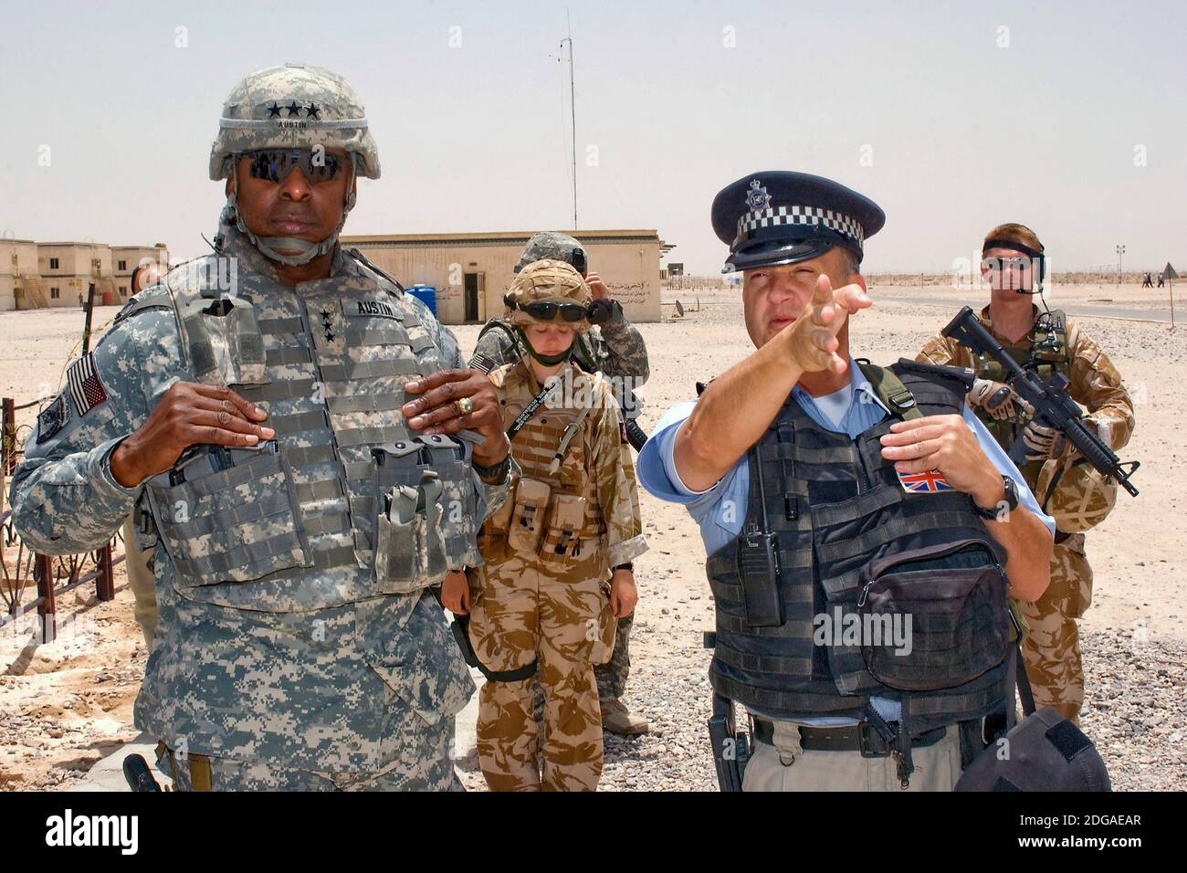 Un policía británico escolta al Teniente General Lloyd J. Austin III, comandante de las fuerzas multinacionales de Irak, durante una visita al Campamento Shaivah el 4 de mayo de 2008 en Basora, Irak. El campamento de Shaivah es el hogar del Equipo de transición Militar, donde la policía iraquí está entrenada por las fuerzas británicas. Foto de stock