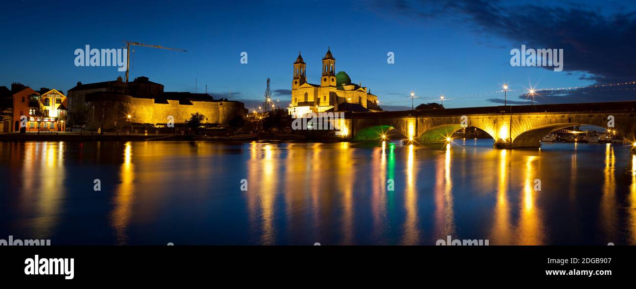 Iglesia de San Pedro y San Pablo con el puente iluminado al atardecer, Río Shannon, Athlone, República de Irlanda Foto de stock