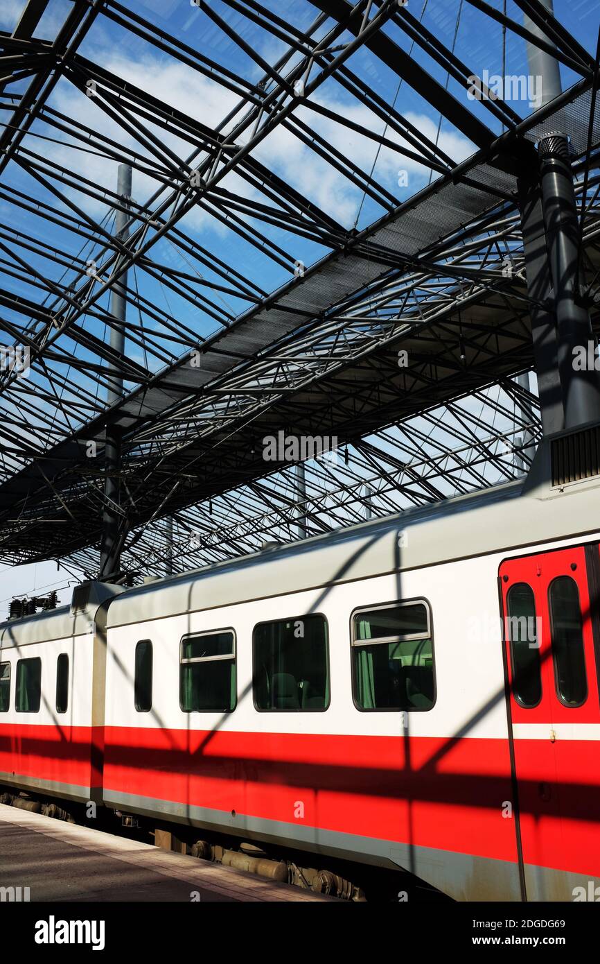 Vagones de un tren de pasajeros bajo una estación de techo de cristal Foto de stock
