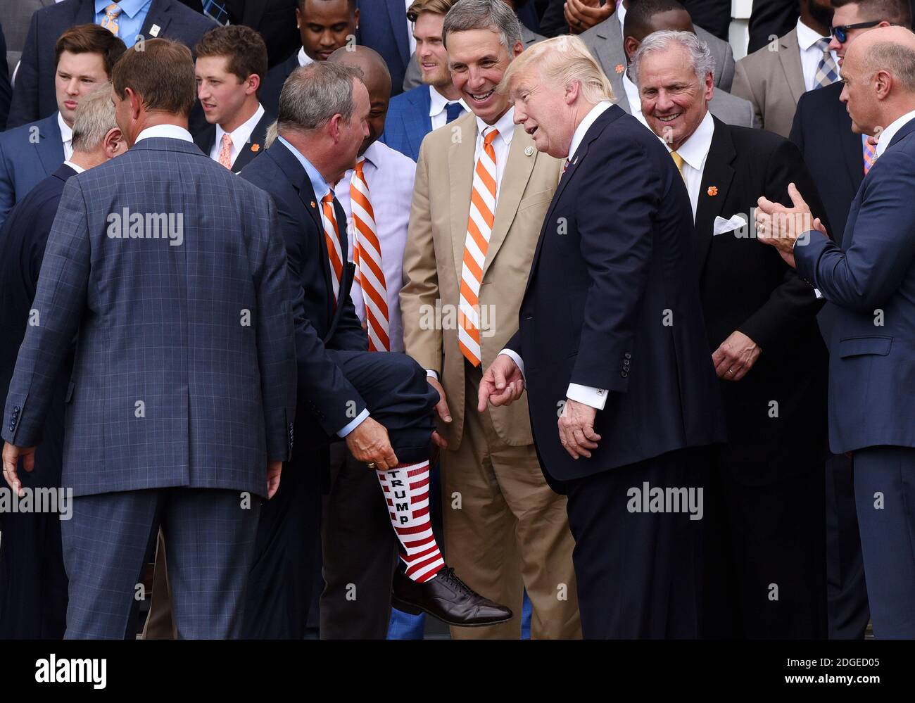 El congresista Jeff Duncan muestra sus calcetines 'Trump' al presidente  Donald Trump durante una ceremonia para dar la bienvenida a los Campeones  nacionales de fútbol de la NCAA de 2016, los Tigres