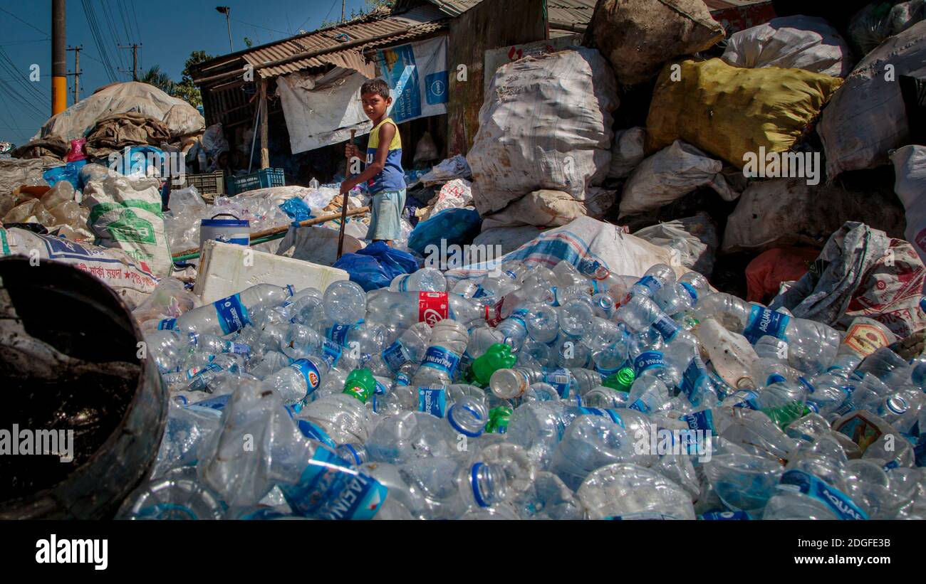 Osman Gony (10) está clasificando botellas de plástico con su padre  Muhammad Kohir en su tienda de reciclaje en Kolatoli cerca de la playa en  Cox's Bazar en Bangladesh. Osman está ayudando