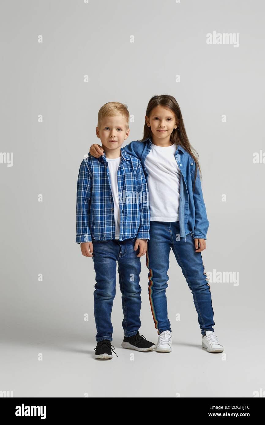 lindo niño y niña con ropa de denim con estilo. dos niños felices Fotografía stock - Alamy