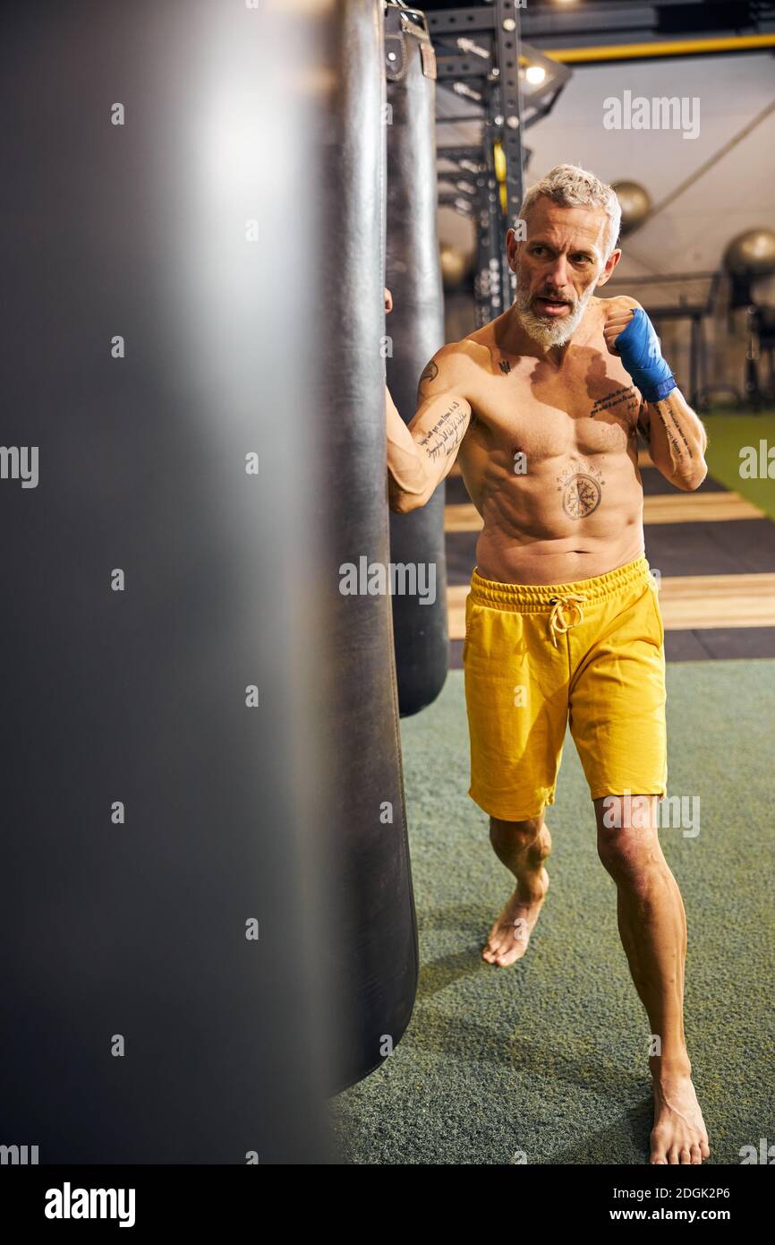 Entrenando duro. Atlético muscular tatuado hombre en ropa deportiva  formación sobre boxeo paws con pareja enfrente de cuadrilátero de boxeo  Fotografía de stock - Alamy