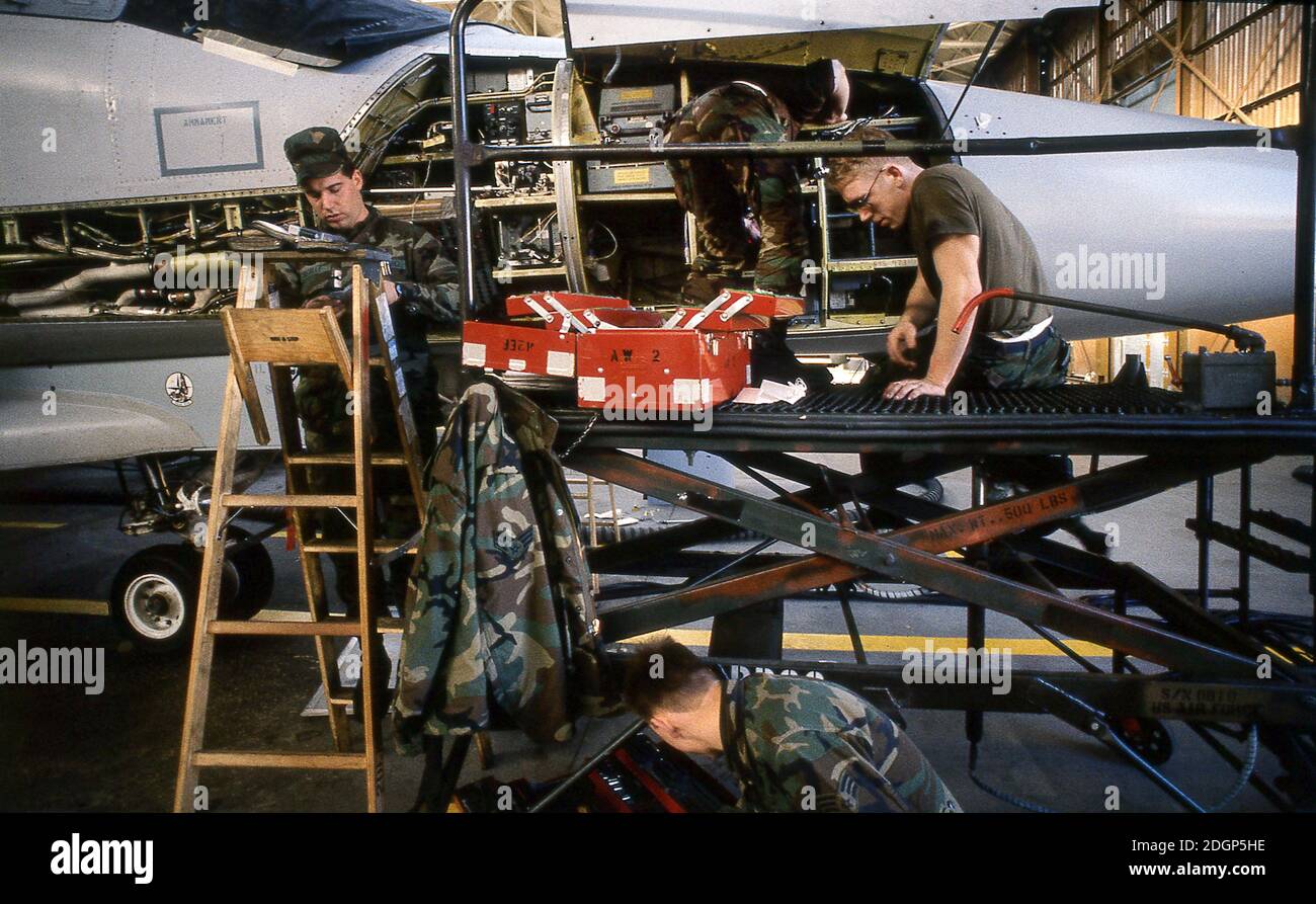 RAF Upper Heyford base aérea Oxfordshire Reino Unido 1990. Hogar del 20º ala táctica de combate USAF. Técnicos de la tripulación de tierra trabajando en F111 Aardvark's en un soporte de base. Foto de stock