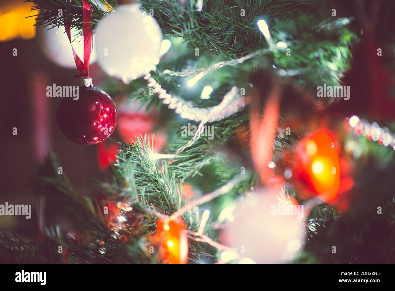 Foto de cerca del árbol de Navidad decorado con bolas, corazones rojos en  la oscuridad pero con luces de Navidad en la víspera de año Nuevo  Fotografía de stock - Alamy