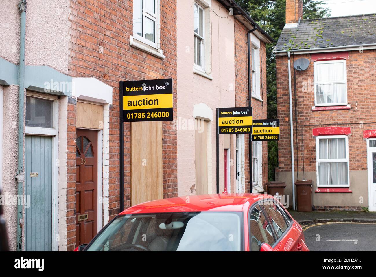 Casa para los letreros de subasta en una calle del Reino Unido. 3 casas listas para ir bajo el martillo Foto de stock