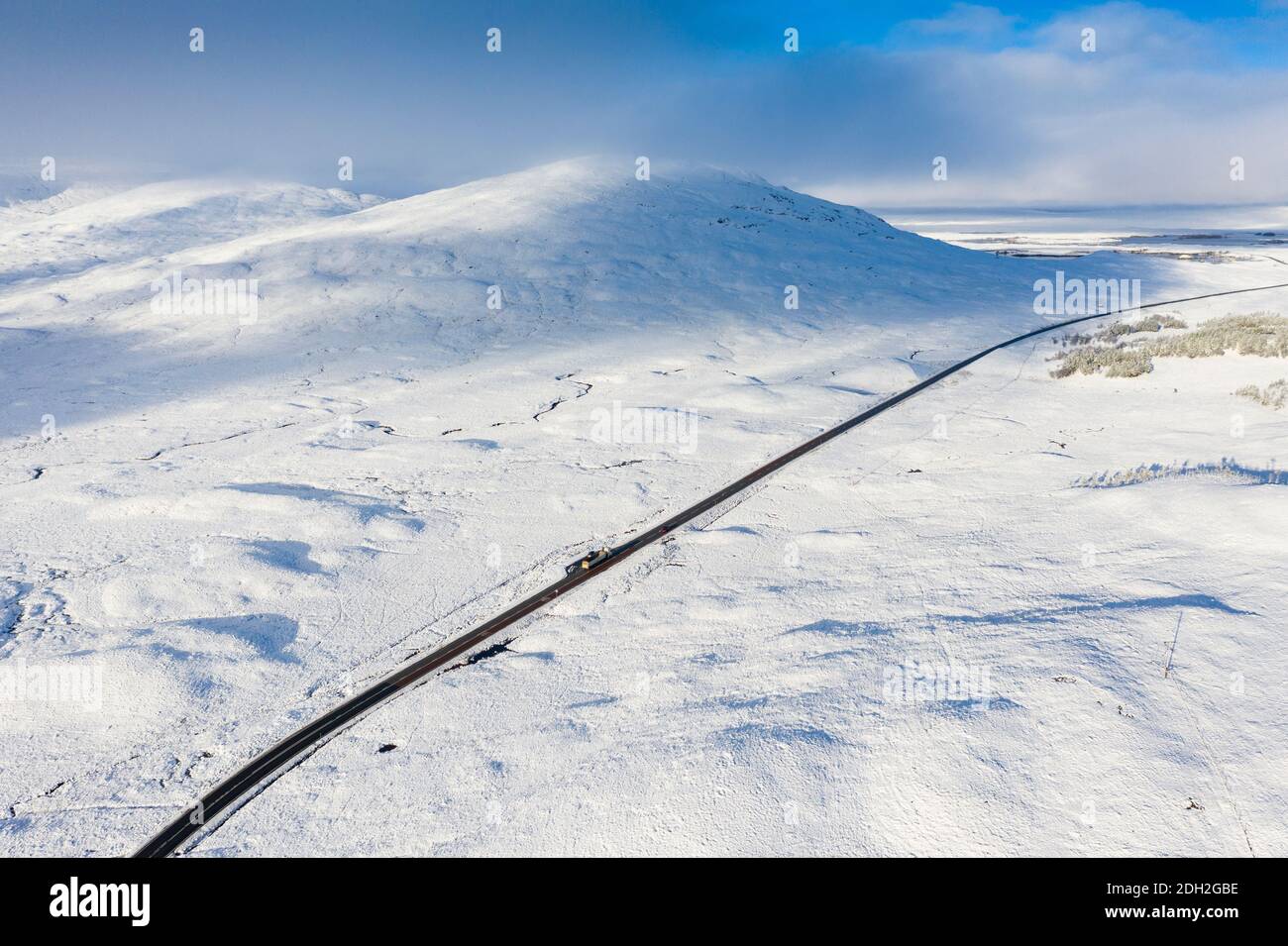 Vista aérea de la carretera A82 cruzando Rannoch Moor cubierto de nieve durante el invierno, Highlands, Escocia, Reino Unido Foto de stock