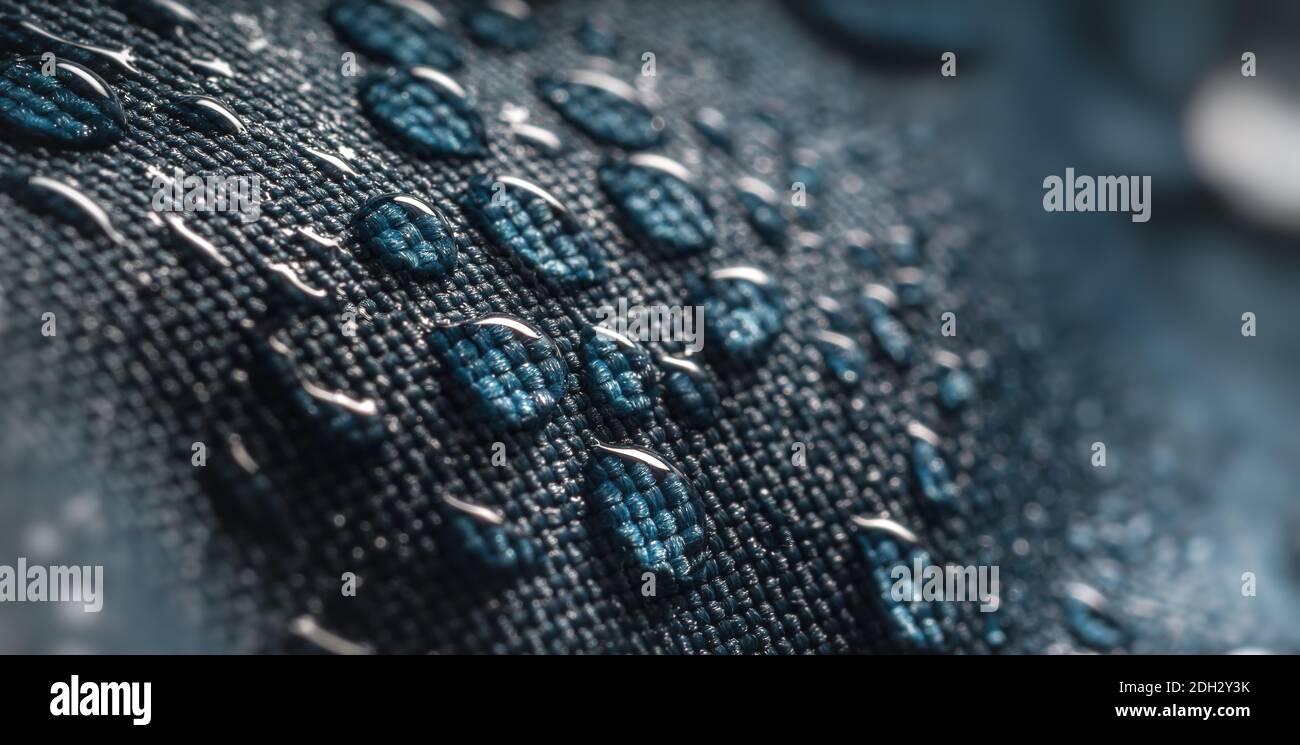 Gotas de agua sobre tejido de membrana impermeable. vista detallada de la  textura de la tela impermeable azul.
