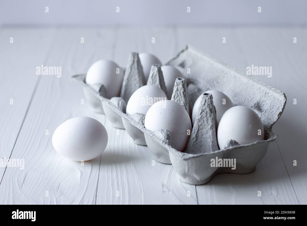 huevos blancos sobre fondo blanco de madera Foto de stock