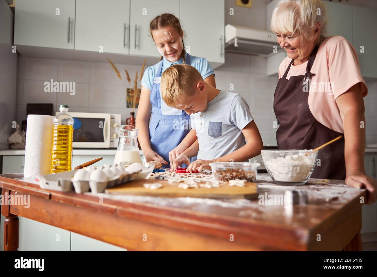 Familia feliz aprendiendo a cocinar en casa Foto de stock