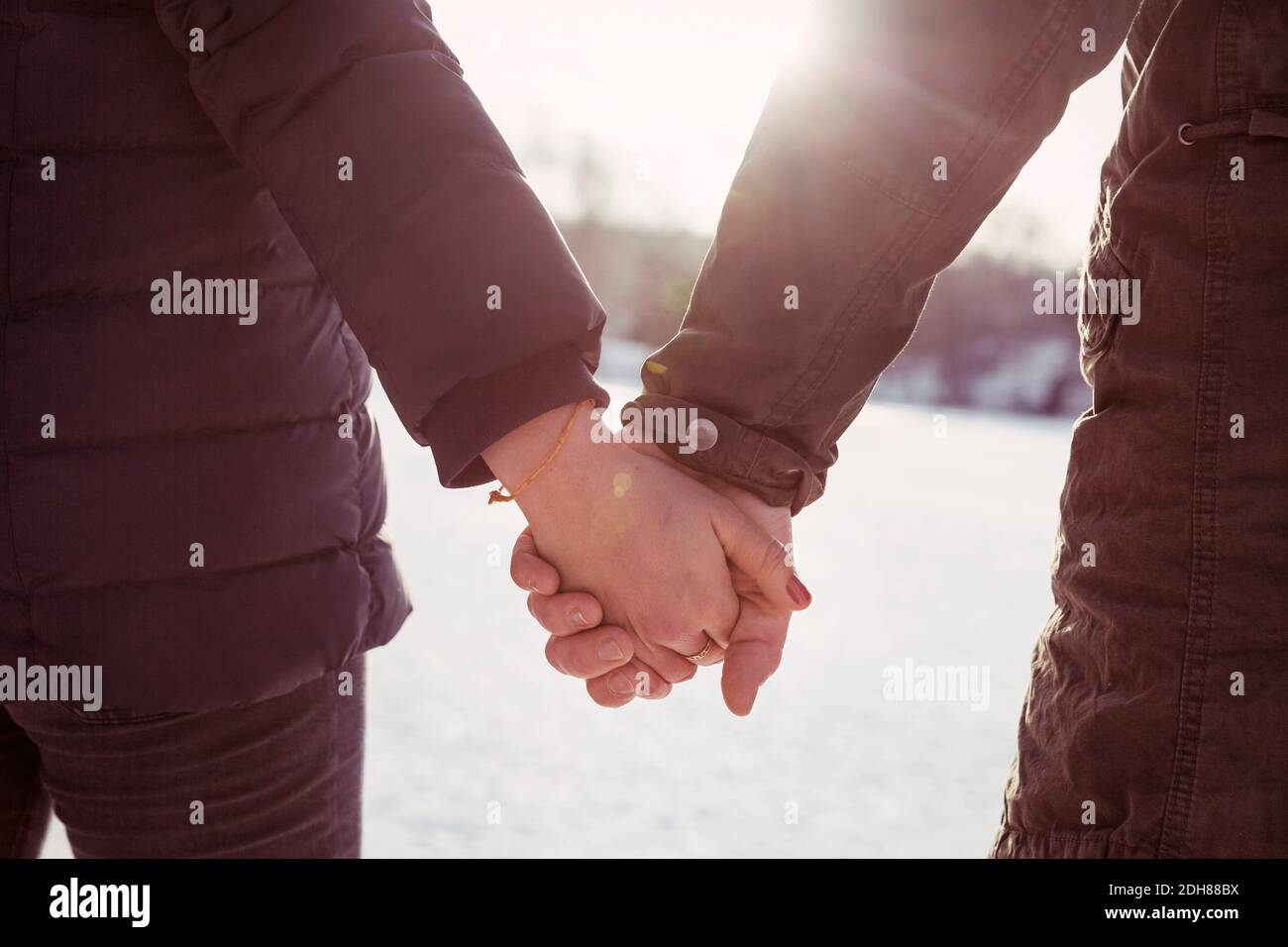 Imagen recortada hombre y mujer hiker sosteniendo las manos durante el invierno Foto de stock