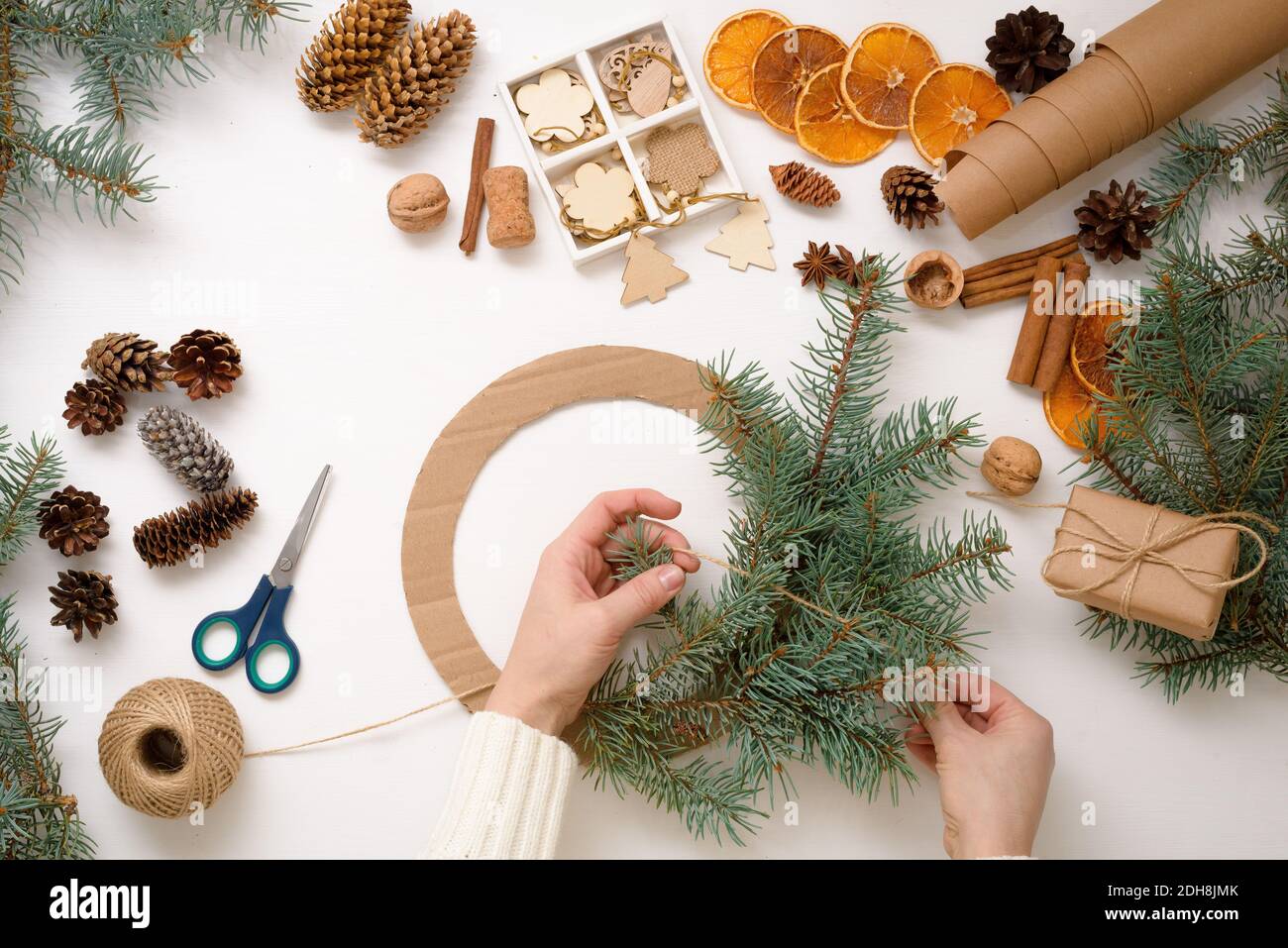Proceso paso a paso de hacer guirnalda de árbol de Navidad en casa de ramas  de abeto, naranjas y juguetes ecológicos de madera en 2021 Fotografía de  stock - Alamy