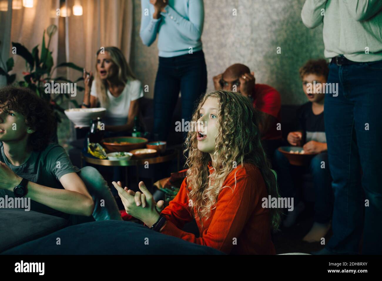 Una familia decepcionada viendo deportes en la televisión por la noche Foto de stock