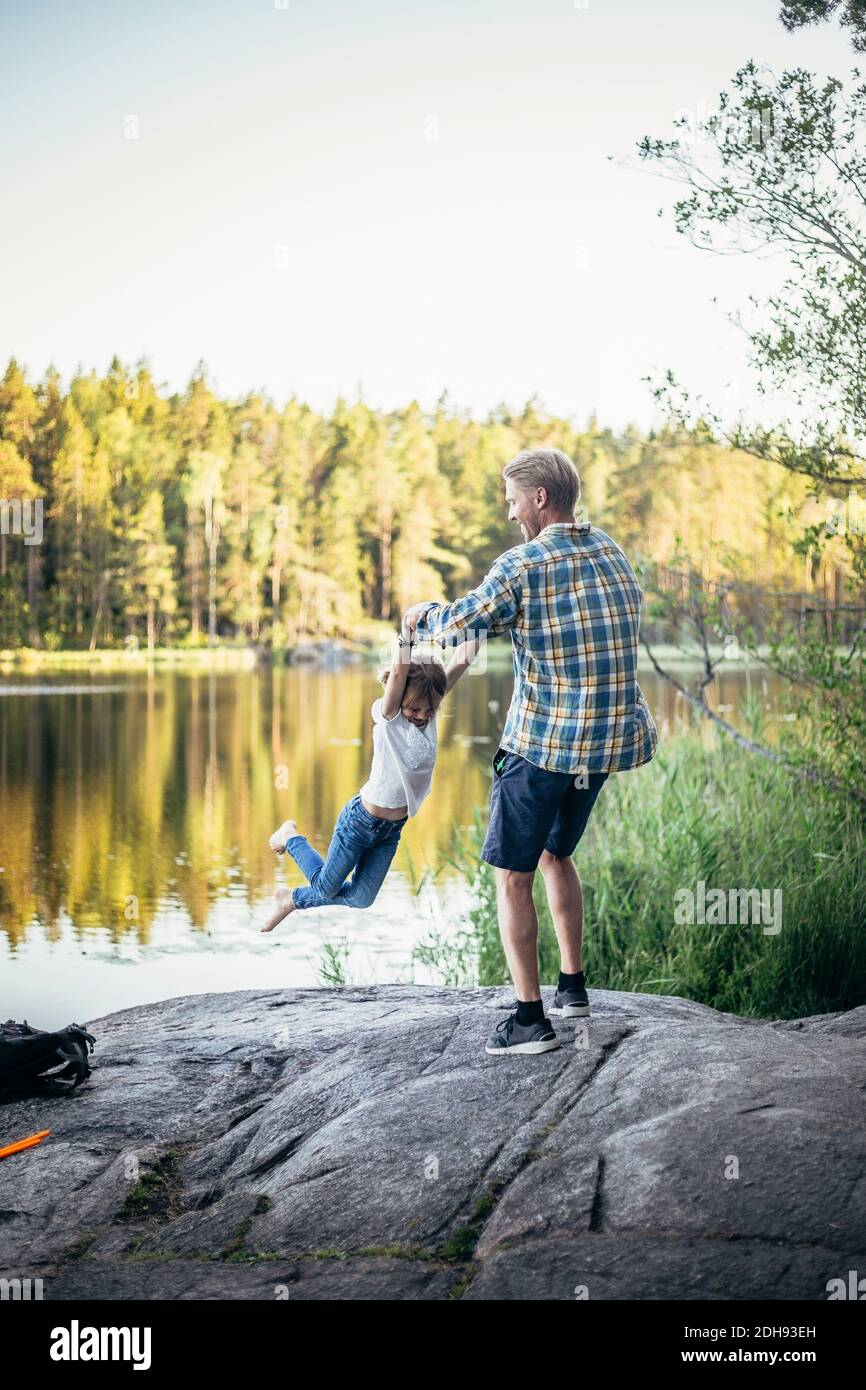 Feliz padre girando hija en el lago Foto de stock