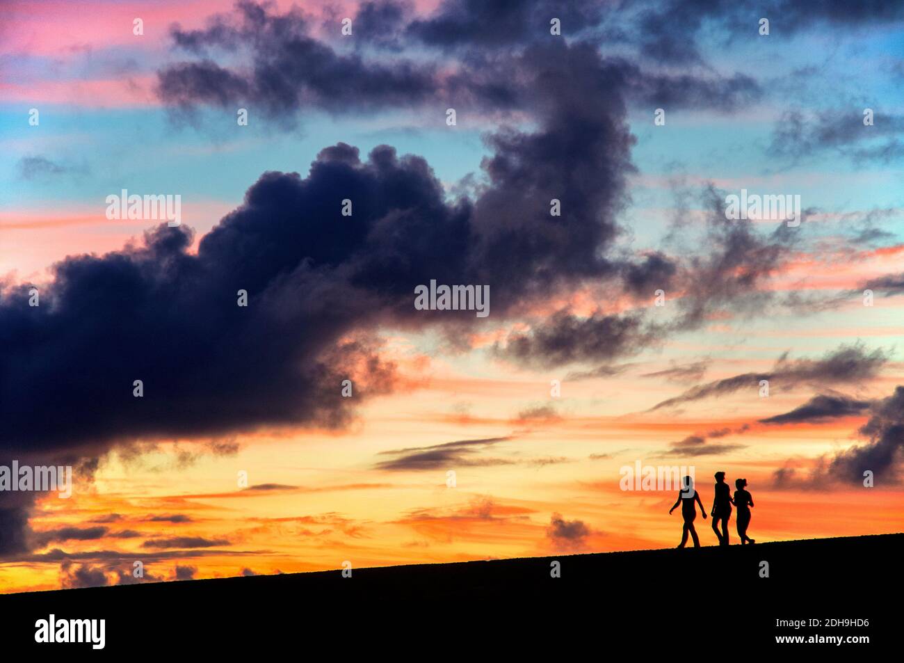 Siluetas de tres chicas caminando al atardecer, Puerto de la Cruz, España  Fotografía de stock - Alamy