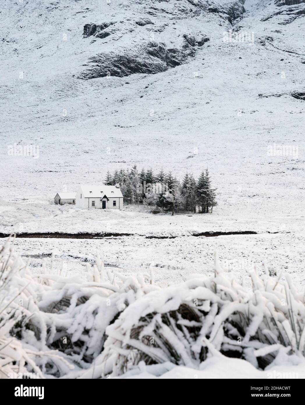 Paisaje invernal cubierto de nieve y casa rural en Glen Coe en Scottish Highlands, Escocia, Reino Unido Foto de stock